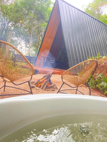 two chairs sitting in front of a fire pit at Sítio Aroeira Cabanas in Sao Jorge