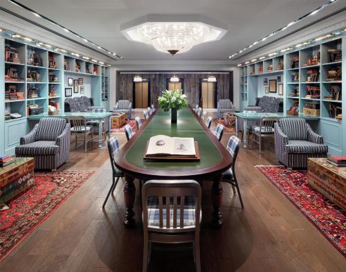 a dining room with a table and chairs and bookshelves at Graduate by Hilton State College in State College