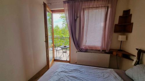 Schlafzimmer mit einem Bett und einem Fenster mit einem Balkon in der Unterkunft Apartment in Balatonlelle 34439 in Balatonlelle