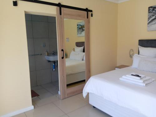 a bedroom with a bed and a shower and a bathroom at Naliya Guest house in Cape Town