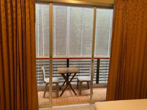 a table and chairs in a room with a window at The Orchid House - SHA Extra Plus in Kata Beach