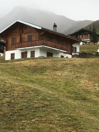 a house on top of a hill with a field at Chalet Lueg uf Belalp in Rosswald