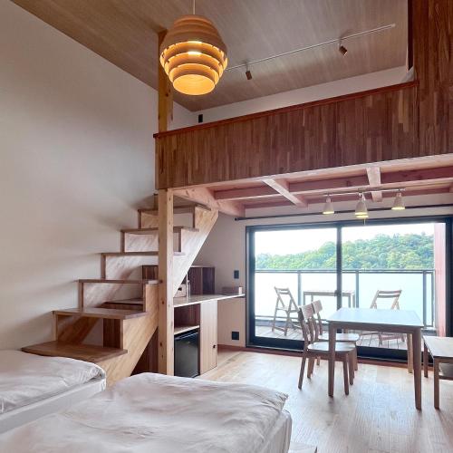 a bedroom with a staircase and a table and a dining room at MY LODGE Naoshima in Naoshima