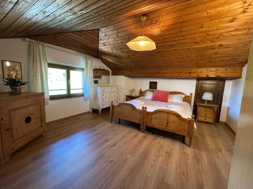a bedroom with a bed and a wooden ceiling at Trentino Appartamenti Oss in Tenna 