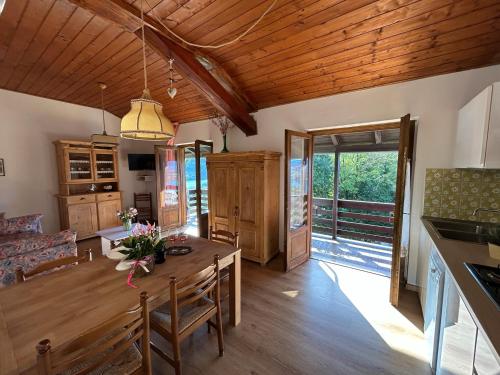 a kitchen and living room with a wooden ceiling at Trentino Appartamenti Oss in Tenna 