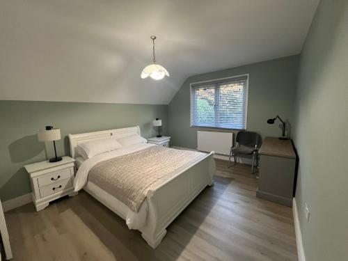a bedroom with a bed and a desk and a window at Private Guest House with full kitchen living room and utility room Completely Separate from the Main House in Cobham