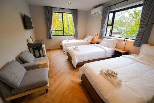 a hotel room with two beds and a chair at Fuji Elegance Hotel in Yamanakako