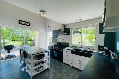 a kitchen with a sink and a stove top oven at Villa paisible avec piscine in Bercloux