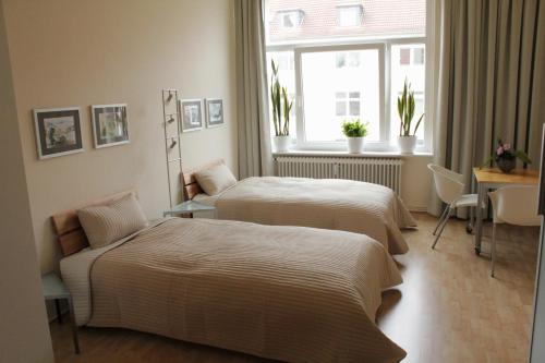 a hotel room with two beds and a window at Zweitbettzimmer Two-bed room in Hannover