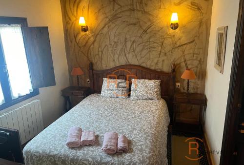 a bedroom with a bed with slippers on it at 15A08 El Rosal By R2R in Buelna