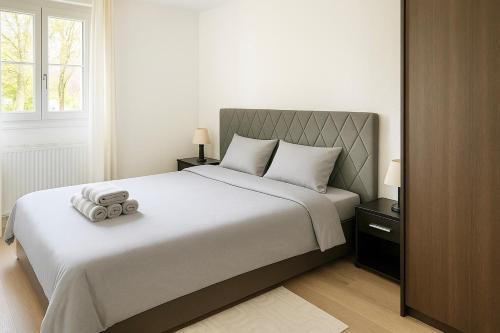 a bedroom with a large bed with two towels on it at Cozy Marquette apartment 10 min from Lille center in Marquette-lès-Lille