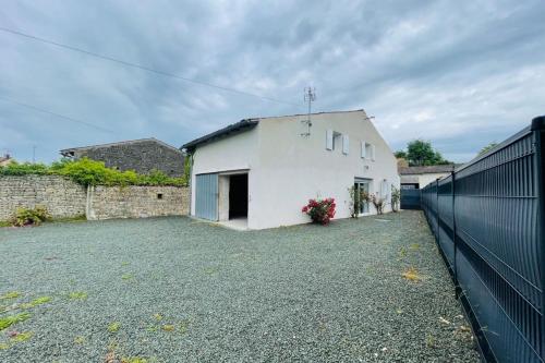 ein weißes Haus mit einem Zaun davor in der Unterkunft Maison les mottes-cour et garage in Asnières-la-Giraud