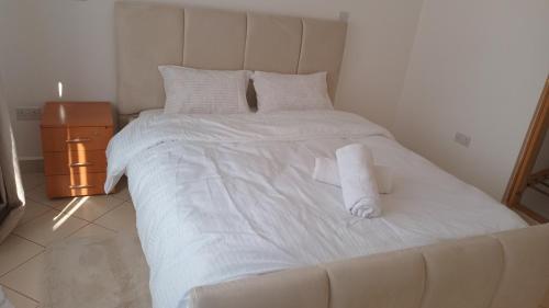 een groot wit bed met twee handdoeken erop bij makao apartment in Nairobi