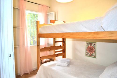 a bedroom with two bunk beds and a window at La casita del oso in Linares de la Sierra
