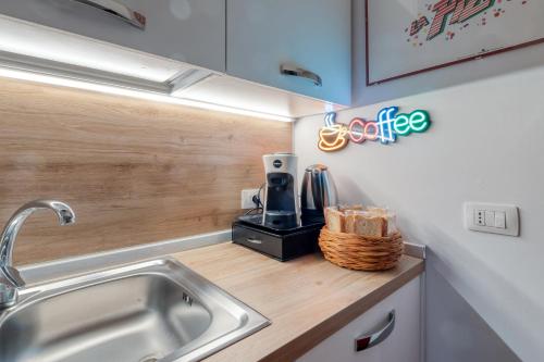 a kitchen with a sink and a coffee maker on a counter at Fore te capu casavacanze Lecce in Lecce