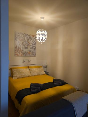 a bedroom with a large yellow bed with a chandelier at Ca' Tecla in Asti