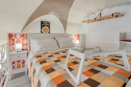 a bedroom with a white bed and a table at Fore te capu casavacanze Lecce in Lecce