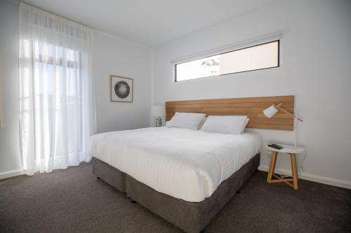 a bedroom with a large white bed and a window at Island Quarters in Whitemark