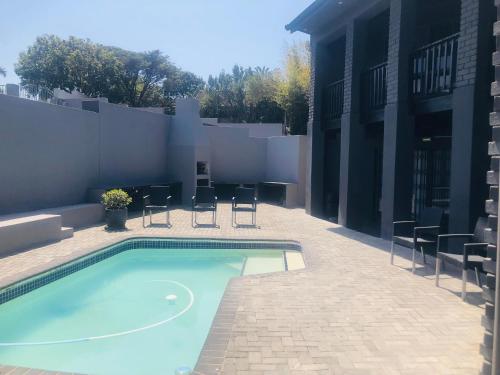 ein Pool neben einem Gebäude in der Unterkunft 2 Seasons Guesthouse East London in East London
