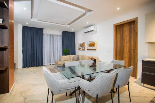 a living room with a glass table and chairs at 233 Boulevard by QUAO REALTY in Accra