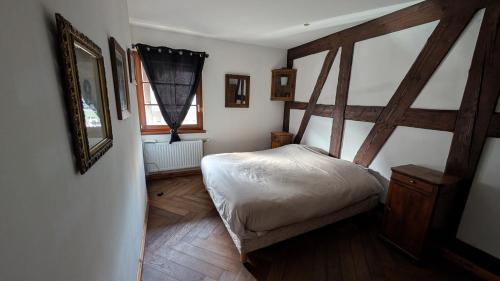 ein kleines Schlafzimmer mit einem Bett und einem Spiegel in der Unterkunft Les Perles du Ried - Gîte 201 in Boofzheim