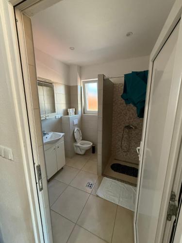 a bathroom with a shower and a toilet and a sink at Sobe Holiday Goražde in Goražde