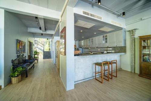 a large kitchen with white cabinets and wooden floors at Black Pearl 8 Bedroom Beach Villa Private Pool Gym Free Car Free Water and Electricity Maid 10 Meters to the Beach in Mai Khao Beach