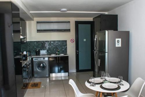 una cocina con una mesa y un refrigerador en Twilight Self Catering, en Windhoek