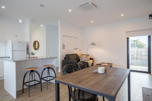 uma cozinha e sala de estar com uma mesa de madeira e cadeiras em Island Quarters em Whitemark
