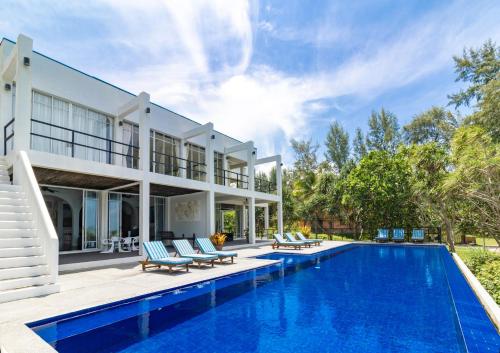 an exterior view of a villa with a swimming pool at Black Pearl 8 Bedroom Beach Villa Private Pool Gym Free Car Free Water and Electricity Maid 10 Meters to the Beach in Mai Khao Beach