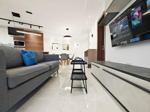 a living room with a couch and a tv at Valley View 1 in Luqa