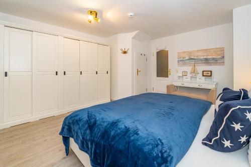 a bedroom with a blue bed and a desk at Altstadttor 17 in Westerland