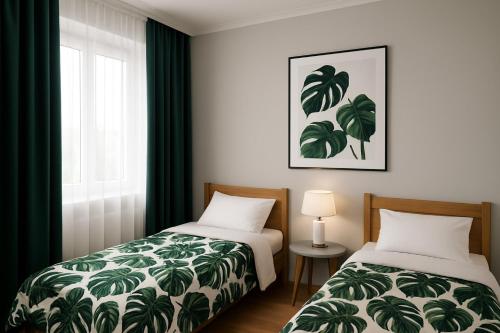 2 camas en una habitación con cortinas verdes y ventana en TK Apartments Namysłów, en Namysłów