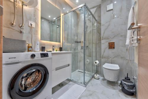 ein Badezimmer mit Waschmaschine und Dusche in der Unterkunft Apartmani Gomax 3,4 & SPA Zlatibor in Zlatibor