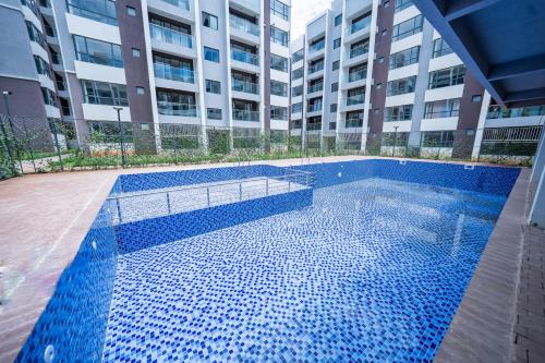 une piscine devant un bâtiment dans l'établissement Farrey Homes Studio Near Jkia and Sgr, à Syokimau