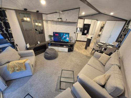 a living room with a couch and a tv in it at Sirrah Villa - Whitstable, Family & Pet friendly in Seasalter