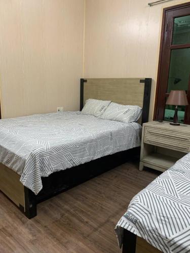 a bedroom with a bed and a table with a lamp at LushStay Cao Bá Quát in Hanoi