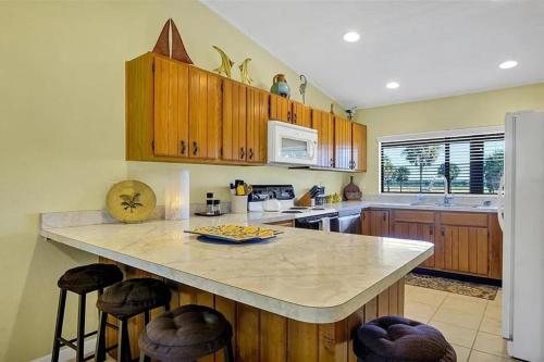a kitchen with wooden cabinets and a large island with bar stools at Perfect blend of comfort Lake Wales in Lake Wales