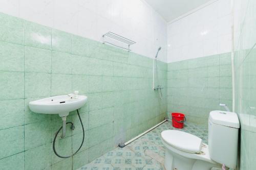a bathroom with a toilet and a sink at Urbanview Ava Guest House Goa Gong in Jimbaran