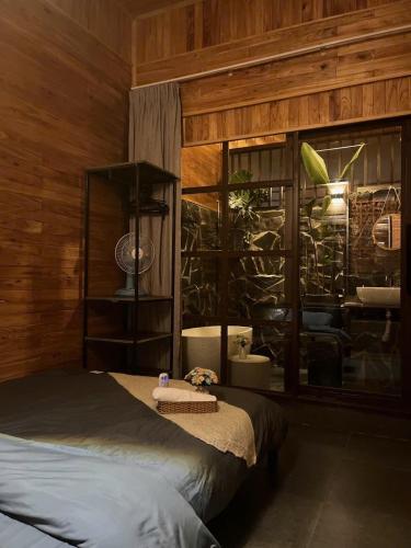a bedroom with a bed in a wooden wall at Villa Cô Ba 2 in Da Thanh