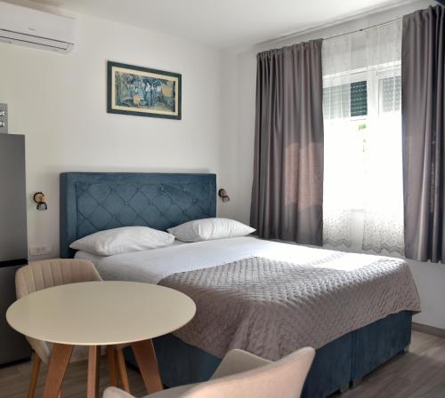 a small bedroom with a bed and a table at Apartments and Rooms Tomas in Podstrana