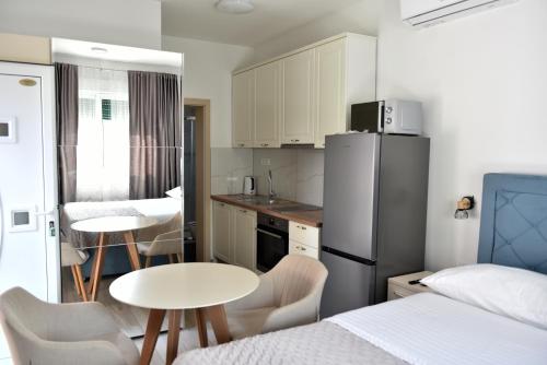 a kitchen with a refrigerator and a table and chairs at Apartments and Rooms Tomas in Podstrana