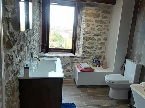 a bathroom with a sink toilet and a window at Chambre double chez Emilienne 