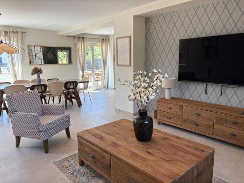 ein Wohnzimmer mit einer Vase aus Blumen auf einem Couchtisch in der Unterkunft Villa des Roches - Labeaume in Labeaume