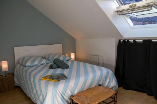 een slaapkamer met een bed met een boek erop bij Bel appartement centre de Cancale in Cancale