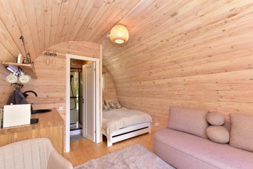 a living room with a couch and a bedroom at Mileikių sodyba namelis dviems in Šarkiškės