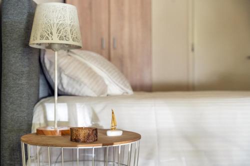 a lamp on a table next to a bed at Γκαρσονιέρα 1 δίπλα στη θάλασσα! in Antikyra