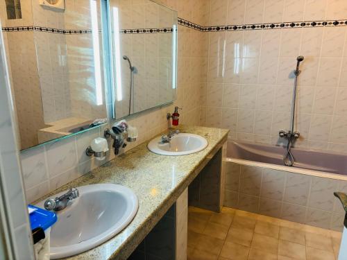 a bathroom with two sinks and a tub at Raja Beach Hotel in Balapitiya