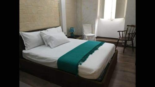 een slaapkamer met een groot bed met witte en groene lakens bij Modern two bedroom apartment in Valletta in Is-Swatar