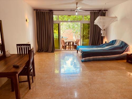 a living room with a bed and a table at Raja Beach Hotel in Balapitiya